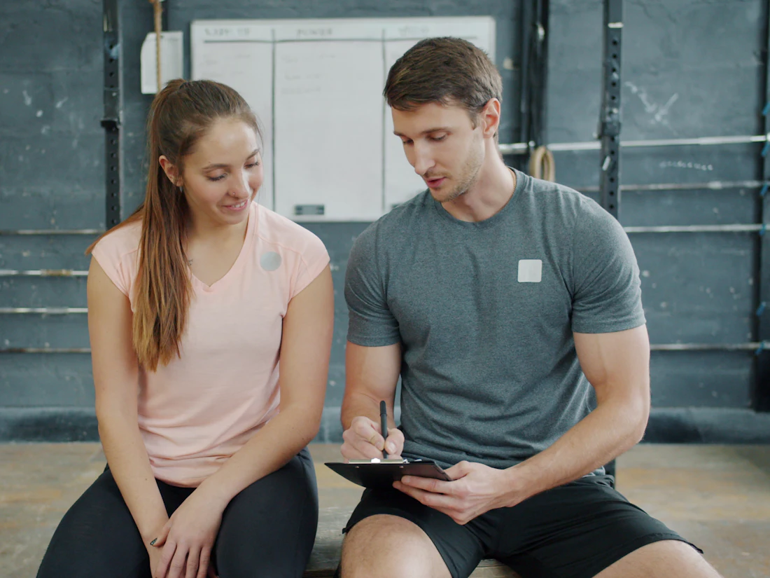 A trainer and client reviewing a workout plan